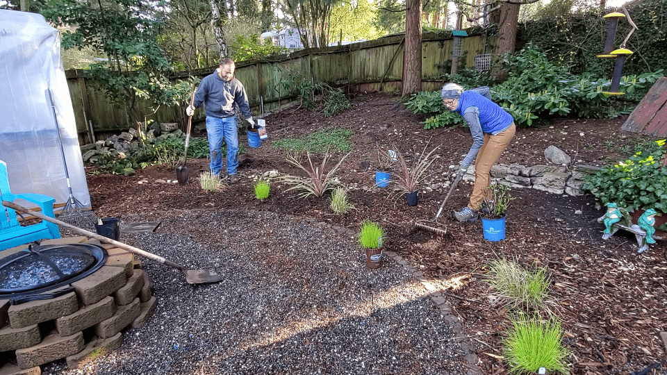 two gardeners planting plants in the ground around other plants in a pattern and design.
